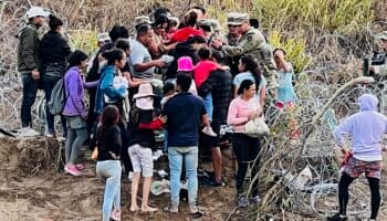 Migrantes abren hueco en alambrada, derriban a oficiales y entran a EU