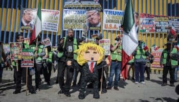 Migrantes protestan y dan nalgadas a piñata de Trump frente al muro fronterizo